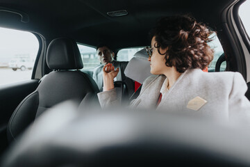 Two business associates engaged in discussion while sitting in a car, symbolizing mobile business meetings.