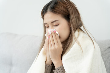 Pollen Allergies, asian young woman sneezing in a handkerchief or blowing in a wipe, allergic to...
