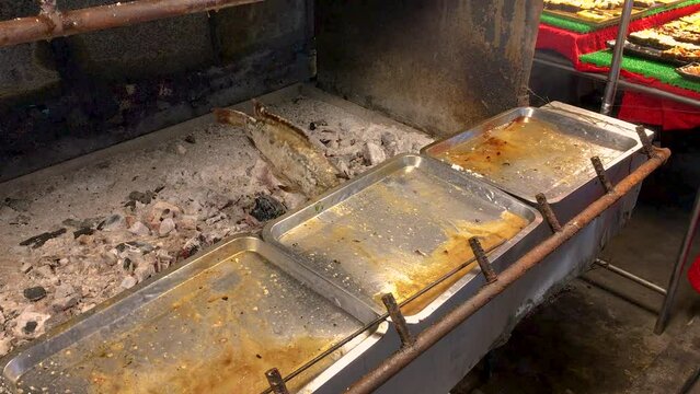 March 5, 2022. Thepprasit Night Market, Pattaya Thailand. Curries, soups and other wet Thai cuisine in metal serving dishes on a vendors table.