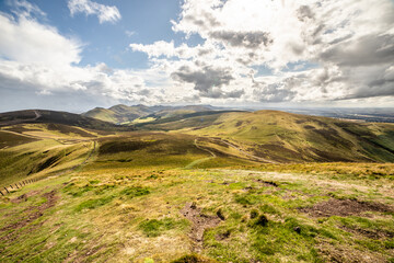 The warm glow of the sun casts a serene ambiance, making this image a perfect addition to projects that evoke the joy and tranquility of sunny days in the heart of Scotland's Pentland Hills.