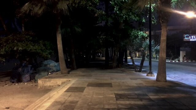 April 5, 2022 - Jomtien Beach, Chonburi, Thailand. Walking along a dark and dimly lit promenade in the early hours of the morning before the sunrise.