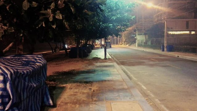 April 5, 2022 - Jomtien Beach, Chonburi, Thailand. Walking along a dark and dimly lit promenade in the early hours of the morning before the sunrise.