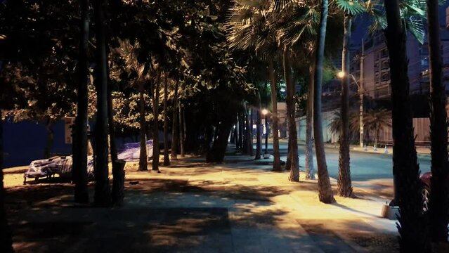 April 5, 2022 - Jomtien Beach, Chonburi, Thailand. Walking along a dark and dimly lit promenade in the early hours of the morning before the sunrise.