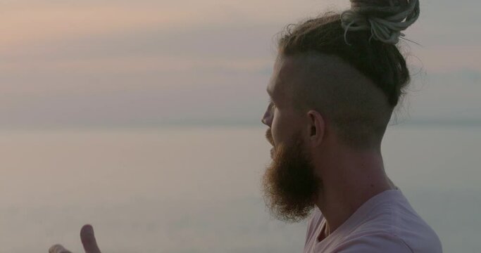 Looking at sea man with beard in deep thought head in close-up Seaside relaxation pondering life's meaning. Seaside relaxation harmonizing with tranquility Seaside relaxation in search of self.