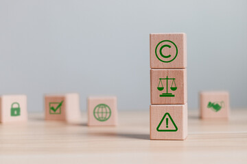 Patented patent copyright law business technology concept. Wooden block with copyright icons for author rights and patented intellectual property.