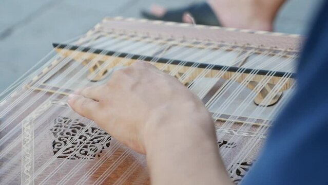 hands of musician playing on cimbalom or dulcimer, 