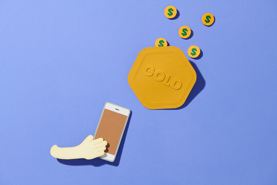 Mobile telephone with gold coin pile isolated on Blue background