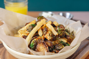 A bowl of food with a side of fries and a glass of orange juice