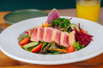 A plate of food with a piece of meat and vegetables