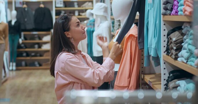 Woman clothing store shopping mall choosing stylish attire Shopping modern lifestyle passion buying beautiful items prosperity highlighted clothing store. Elegant shopping experience clothing store.