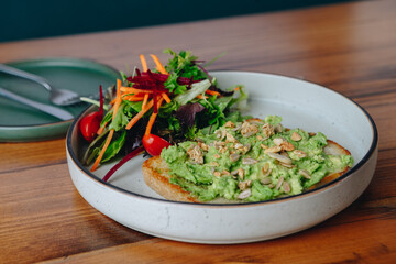 A plate of avocado toast with a side of salad