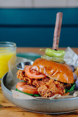 A plate of food with a hamburger on top of a bun and a green pepper