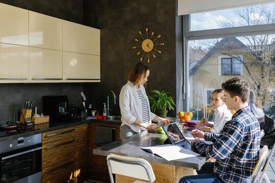 Siblings mother cooking spending time together kitchen