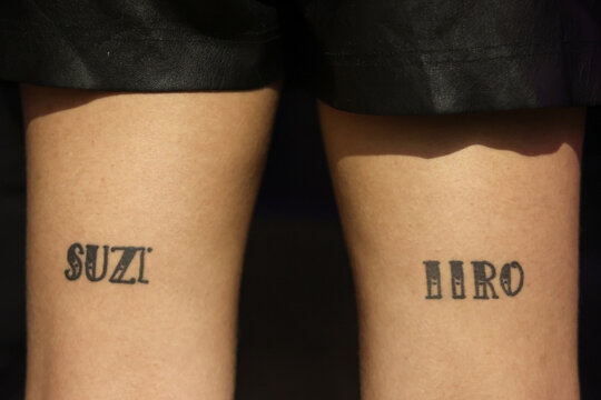Tattoo of names on the back of a woman's tights