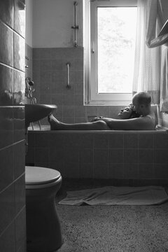 BW image of a couple in a bathtub in old fashioned bathroom