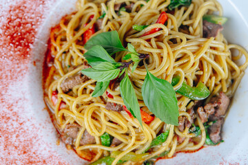A plate of noodles with meat and vegetables