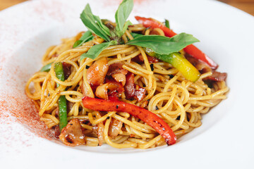 A plate of noodles with meat and vegetables