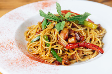 A plate of noodles with vegetables and meat