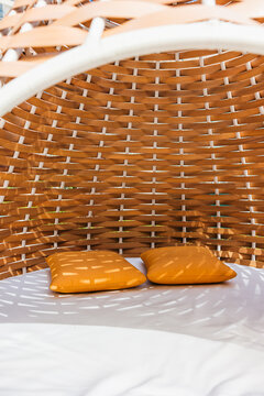 Comfortable woven rattan chair under sunlight.