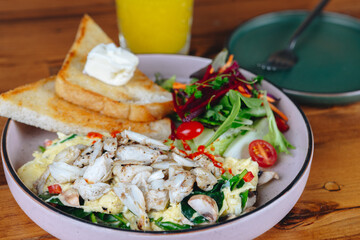A plate of food with a side of toast and a glass of orange juice