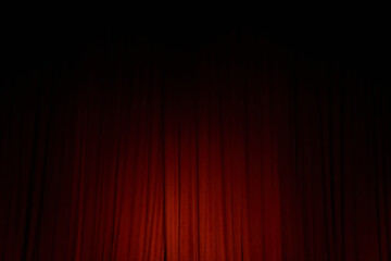 Spot light on the red closed curtain or drapes on stage in theater with copy space. Theatrical...