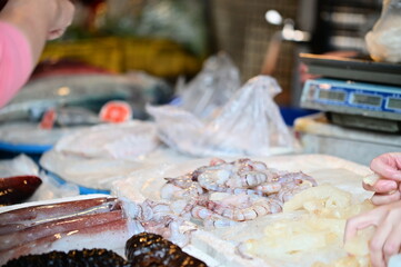 Shelled shrimp displayed at a fish vendor's stall in a traditional market.