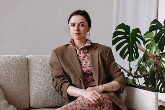 Stylish business woman sitting on couch in office