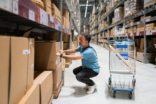 Man Searching For Goods At The Shelf At Warehouse