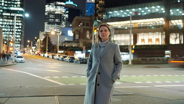 Time lapse of woman standing on illuminated city street at night