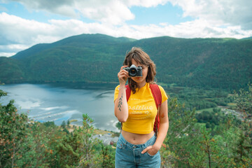 Woman taking photograph of scenic fjord in Norway
