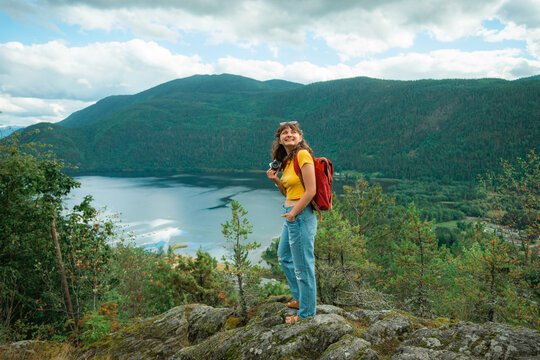 Woman taking photograph of scenic fjord in Norway