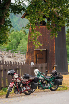 Two motorbikes parked  near the wooden tower in Norway 