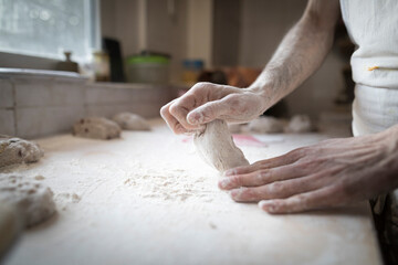 hands knead a loaf of bread