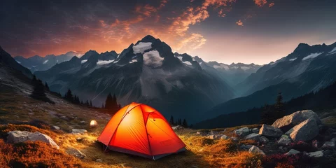 Fotobehang Glowing orange tent camping in the mountains in front of majestic mountain range © Coosh448