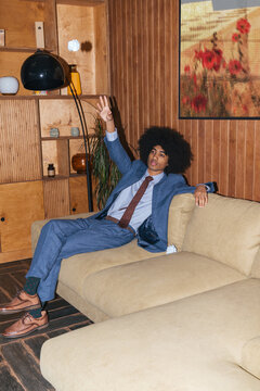 young afro hair styled businessman sitting on couch