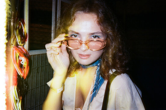 Film photograph of stylish curly hair clubber arriving at nightclub