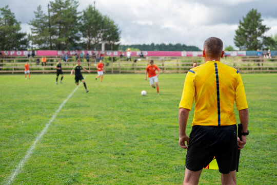 Soccer Referee Overseeing Youth Soccer Teem Match