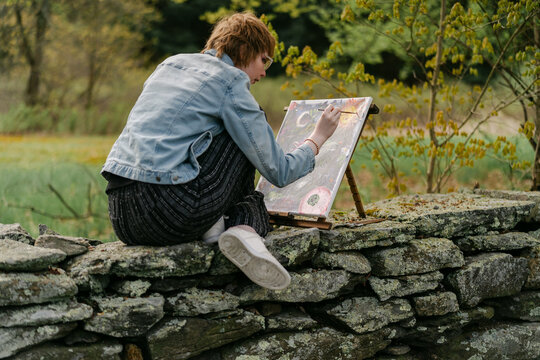 teen artist painting on canvas