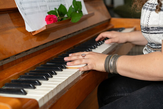 Piano Keys, Female Hands, Music Book, and Rose.