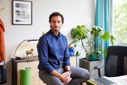Smart businessman sitting on chair in home office