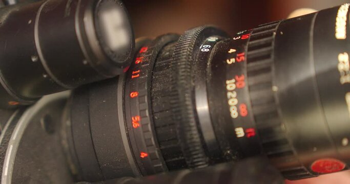 Detail on the lens scale of a film camera while the zoom wheel is turning