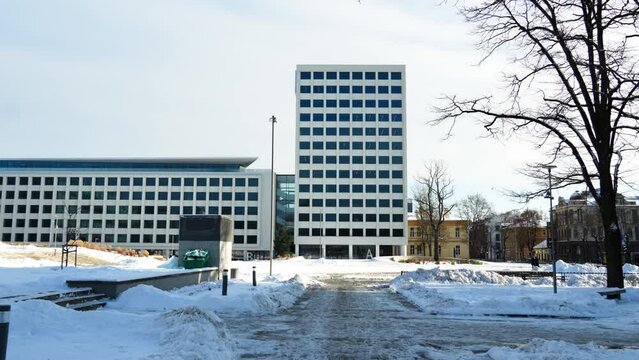 Shot of snow-covered Unity Square with urban buildings in the background in Kaunas, Lithuania during snowy winter