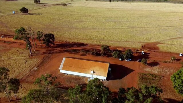 Rotating Drone View of Barn building Faon Farm, Trucks driving by on dirt road