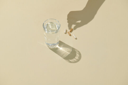 A glass of water and capsules. 