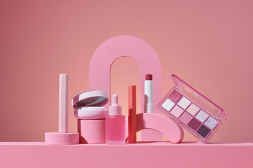Make up products prsented on pink podiums on pink pastel background.