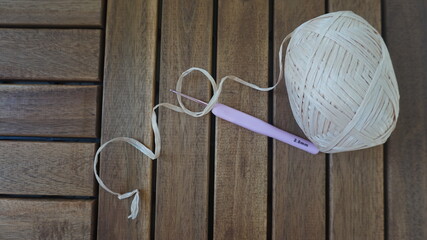raffia balls . A bobbin of yarn lies on hooks. side view of a textile reel. Straw yarn and hook