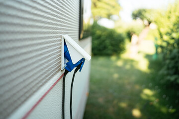 Camper van plugged into external electricity source