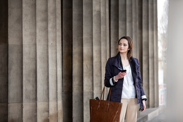 Caucasian business woman using smartphone in front of courthouse.