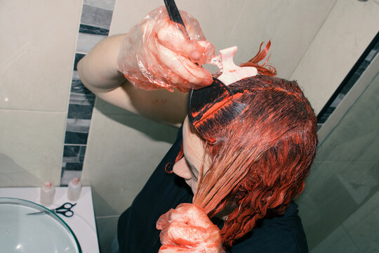 Woman dyeing her hair red