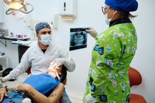 Assistant showing the dentist an image of an X-ray